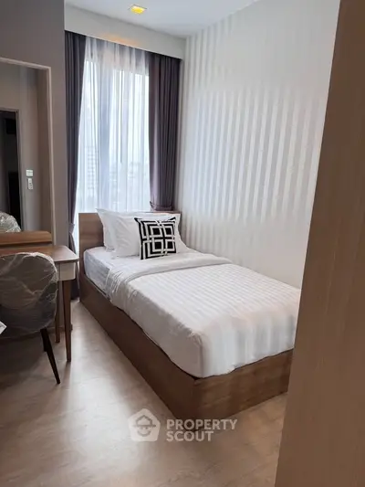 Cozy modern bedroom with single bed and stylish decor in a well-lit apartment.