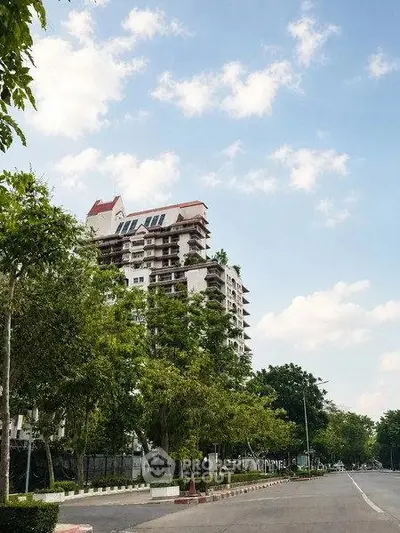 Stunning high-rise building with lush greenery and clear blue sky