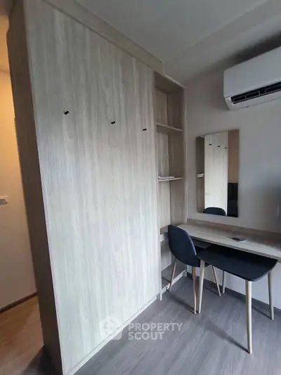 Modern study area with sleek desk and built-in storage in stylish apartment.