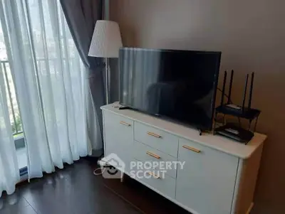 Modern living room with TV, stylish lamp, and balcony view