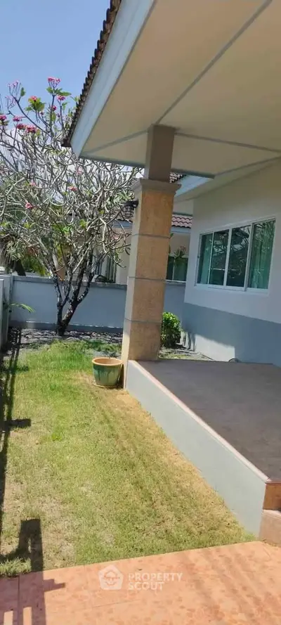 Charming garden view of a modern home with spacious patio and lush greenery.