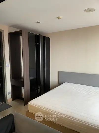 Modern bedroom with minimalist design featuring a sleek wardrobe and comfortable bed.