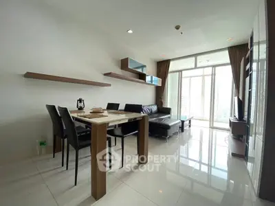 Modern living room with sleek furniture and large windows offering city views.