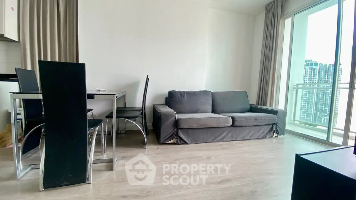 Modern living room with sleek dining set and cozy sofa, featuring a bright balcony view.