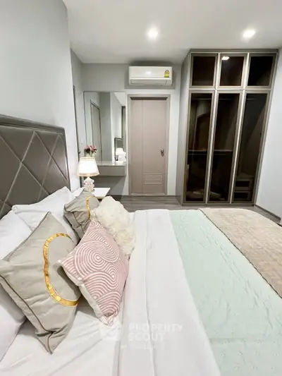 Modern bedroom with stylish decor and built-in wardrobe, featuring cozy bedding and ambient lighting.