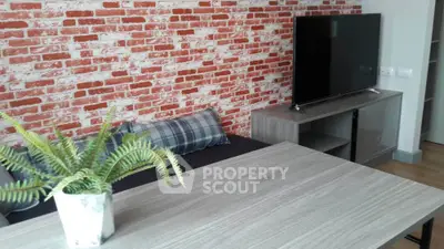 Modern living room with brick accent wall and sleek TV setup