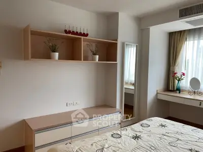 Cozy bedroom with modern decor, featuring built-in shelves and a stylish vanity area.