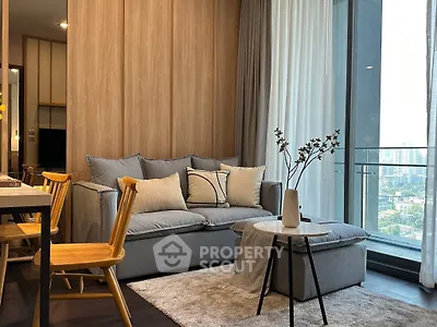 Modern living room with cozy sofa, wooden accents, and city view balcony in luxury apartment.