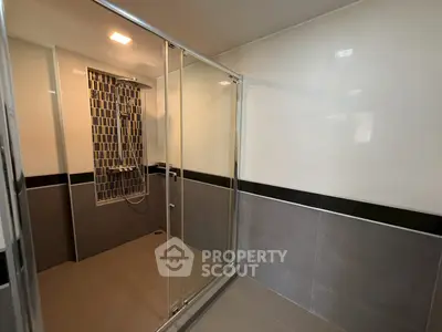 Modern bathroom with glass shower enclosure and stylish tile design