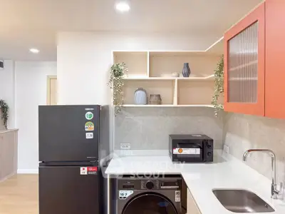Modern kitchen with sleek appliances and stylish shelving in a contemporary apartment.