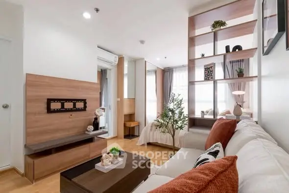 Modern living room with stylish decor and open layout leading to a cozy bedroom.
