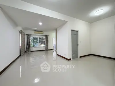 Spacious unfurnished living room with large windows and glossy tiled floors.