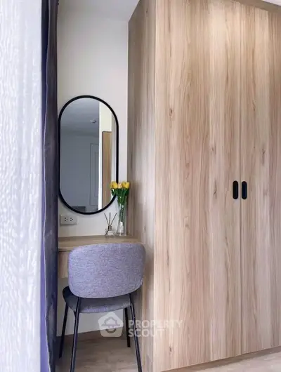 Stylish modern bedroom corner with wooden wardrobe and elegant vanity mirror.