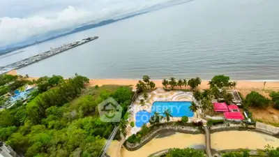 Stunning beachfront property with pool and lush greenery offering breathtaking ocean views.