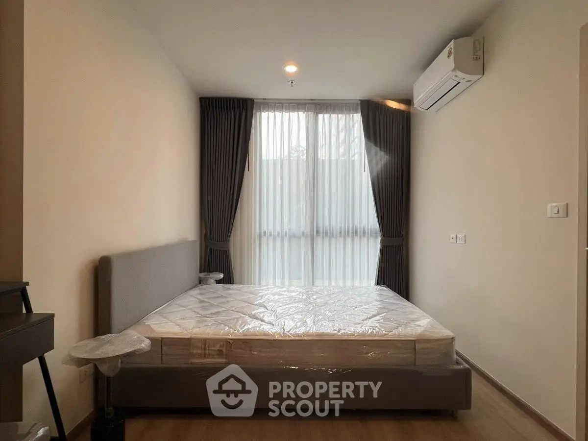 Modern bedroom with large window, air conditioning, and minimalist decor.