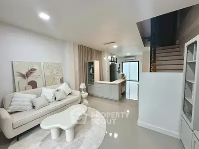 Modern living room with elegant decor and open layout, featuring a cozy sofa and stylish coffee table.