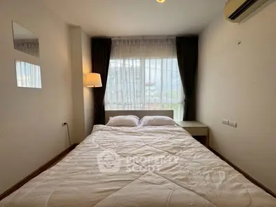 Cozy bedroom with large window and modern decor in a stylish apartment.