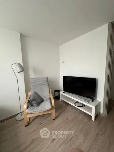 Modern minimalist living room with sleek TV setup and cozy armchair