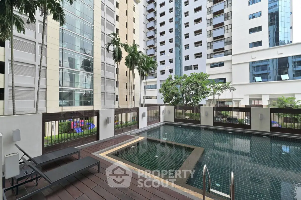 Luxurious apartment complex with modern pool and lush greenery in urban setting.