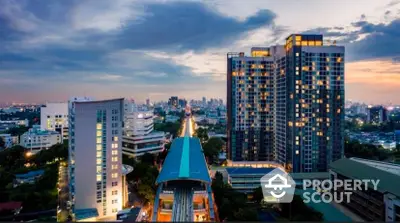 Majestic twin high-rise residential towers illuminated at dusk, offering panoramic city views and modern urban living.