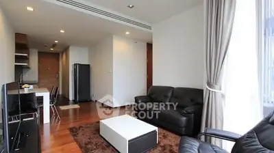 Modern living room with leather sofas and wooden flooring in a stylish apartment.