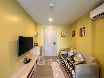 Cozy living room with modern decor, wall-mounted TV, and comfortable sofa in a stylish apartment.