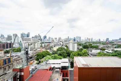 Stunning cityscape view from high-rise building showcasing urban skyline and greenery.