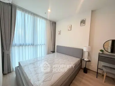 Modern bedroom with large window, stylish decor, and cozy ambiance in a contemporary apartment.