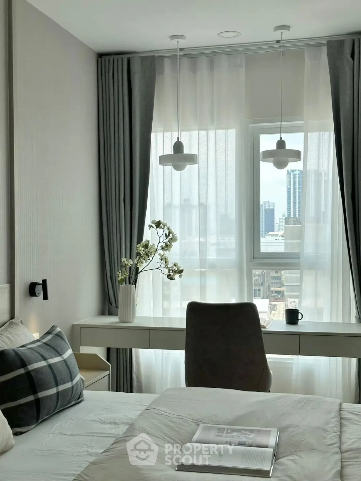 Modern bedroom with city view, elegant decor, and natural light