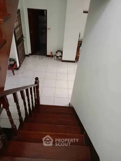 Spacious interior with wooden staircase and tiled floor, perfect for family living.