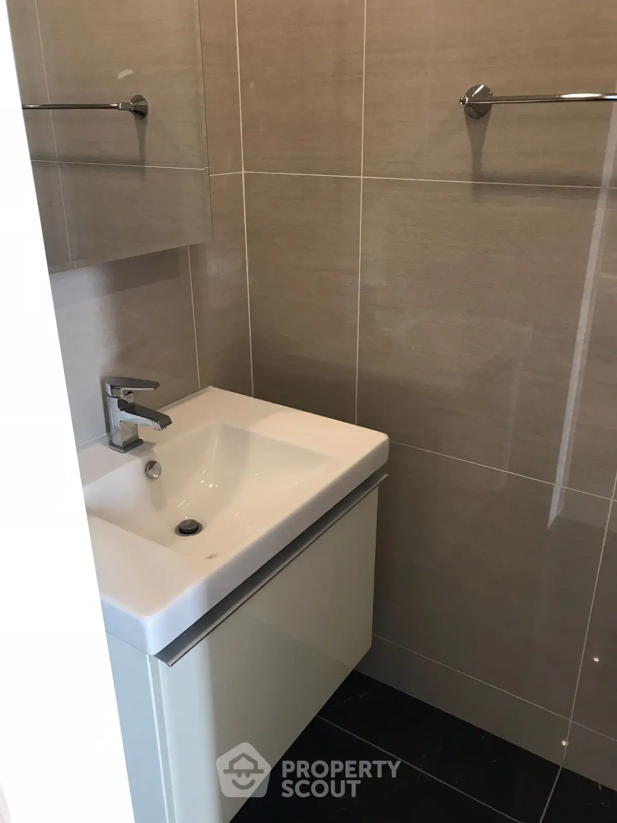 Modern compact bathroom with sleek sink and tiled walls