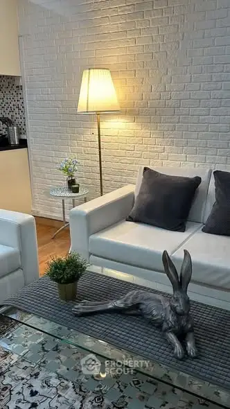 Chic living room with white brick wall, cozy sofa, and stylish decor in modern apartment.