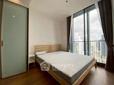 Modern bedroom with large windows offering stunning city view and minimalist decor.
