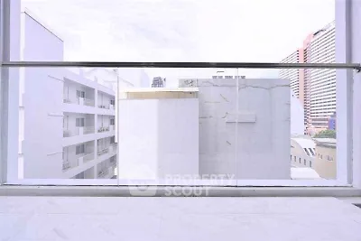 Modern urban balcony with glass railing offering cityscape views.