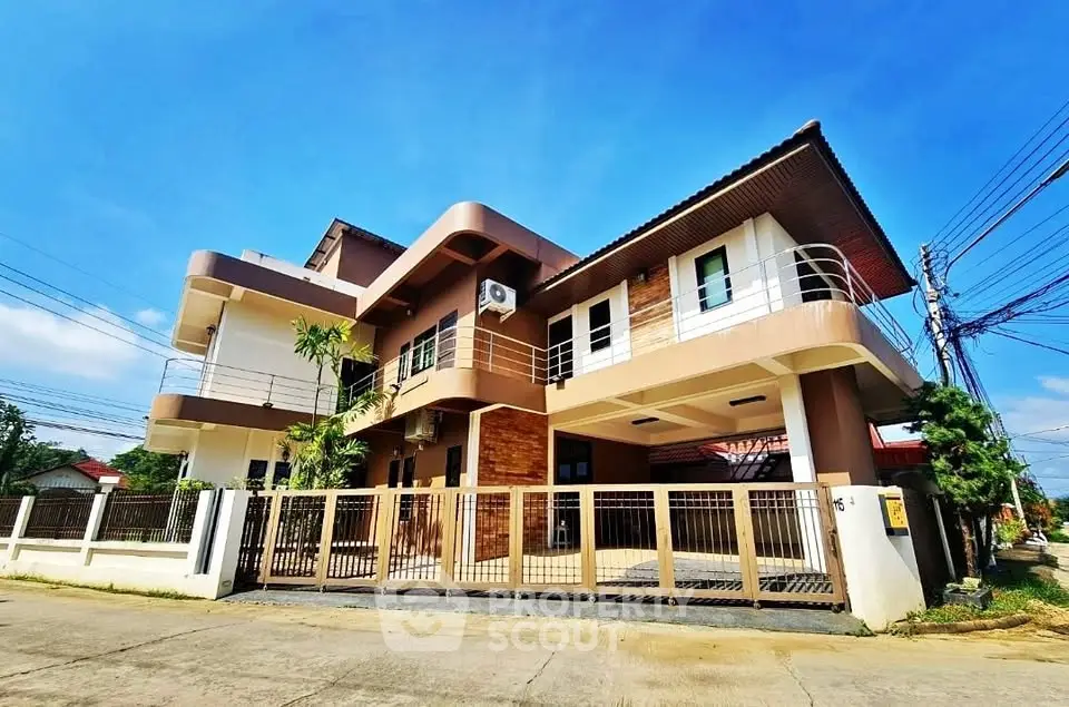 Modern two-story house with unique architecture and spacious balcony in a suburban neighborhood.