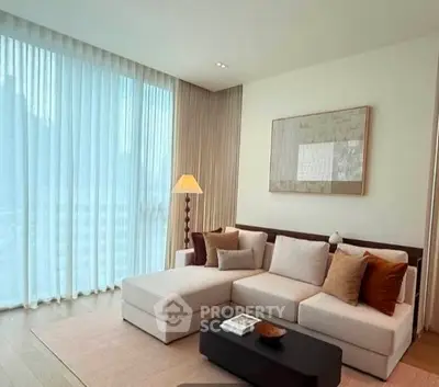 Elegant living room with modern sofa and floor-to-ceiling windows for natural light.
