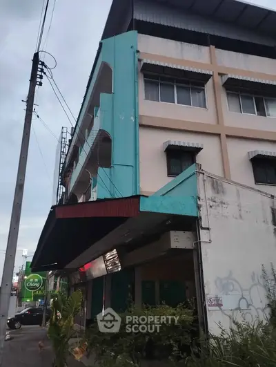 Charming corner building with unique architectural design and vibrant exterior colors, perfect for commercial opportunities.