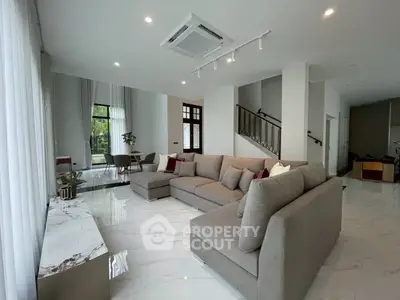 Spacious modern living room with elegant gray sofa and marble flooring
