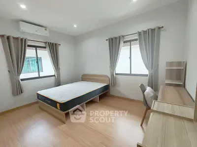Spacious bedroom with modern furnishings and natural light, featuring a comfortable bed and study area.
