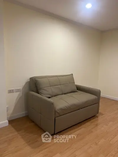 Cozy small living room with modern beige sofa and wooden flooring