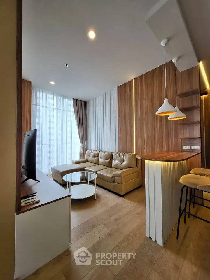 Modern living room with cozy seating and stylish lighting in a high-rise apartment.