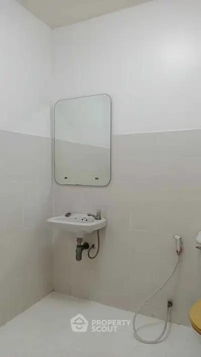 Minimalist bathroom with wall-mounted sink and mirror, ideal for compact spaces.