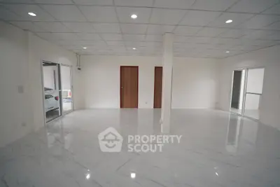 Spacious modern living room with sleek tile flooring and ample natural light