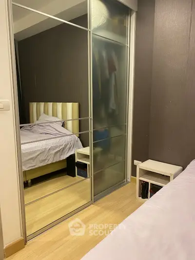 Modern bedroom with mirrored sliding wardrobe and cozy bed