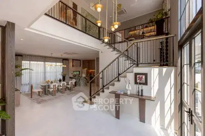 Luxurious open-plan living room with elegant staircase and dining area, featuring modern decor and ample natural light.