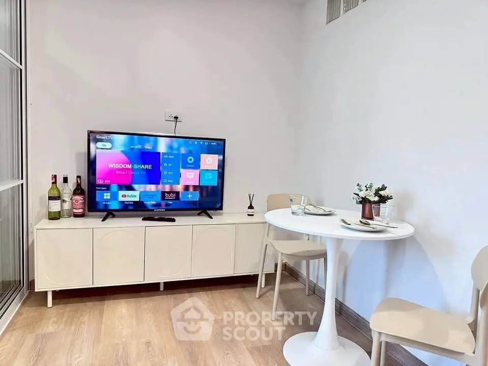 Cozy living room with modern TV setup and dining area, perfect for relaxation and entertainment.