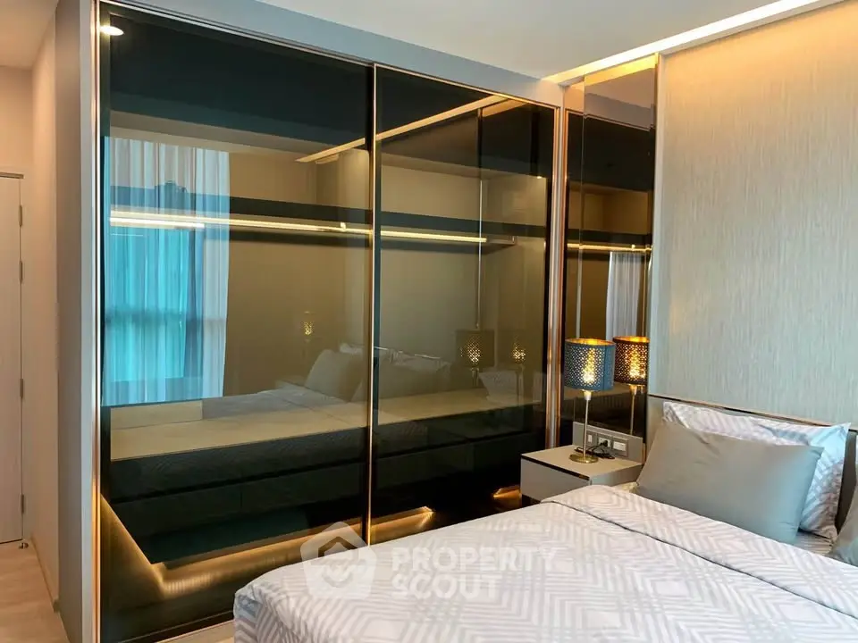 Modern bedroom with sleek mirrored wardrobe and stylish bedding