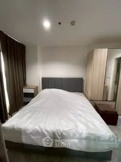 Cozy bedroom with modern furnishings and ample natural light.