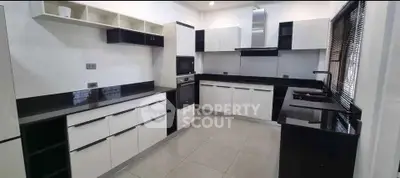 Modern kitchen with sleek black and white cabinetry and built-in appliances