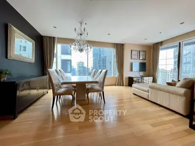 Spacious modern living room with elegant dining area and city view, featuring hardwood floors and chandelier.